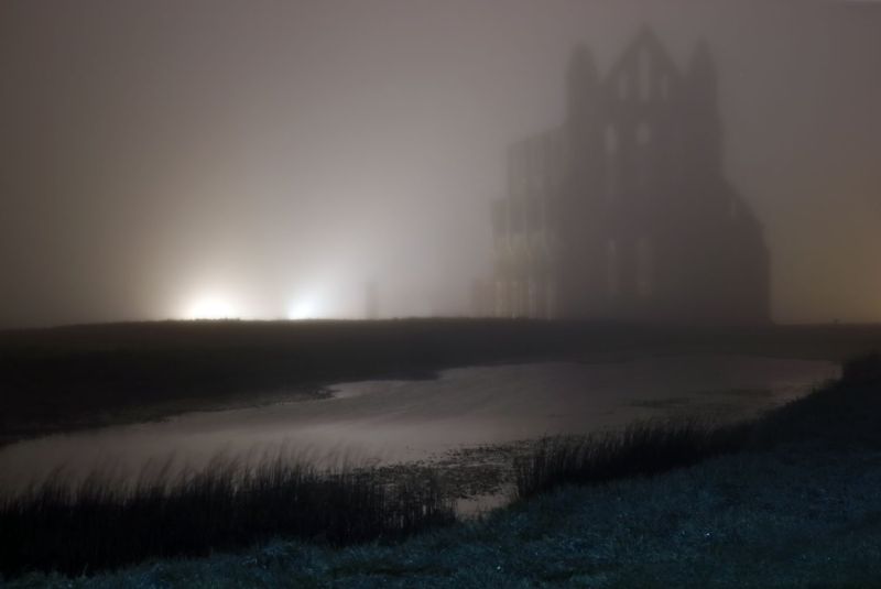 The abbey and pond on a misty night